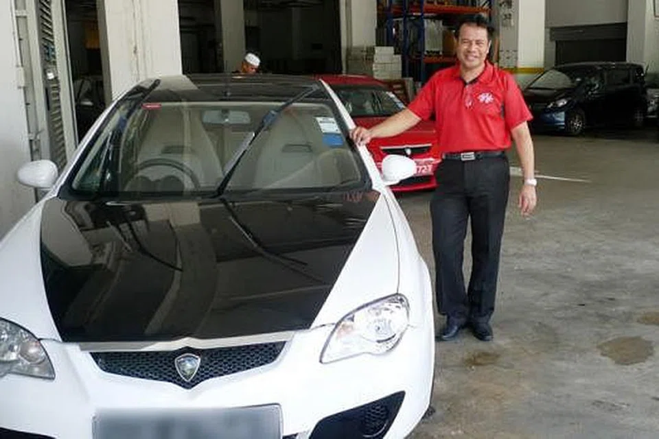 KERETA TERPAKAI PUN ADA HARGA SEKARANG: Encik Azmi bersama sebuah kereta Proton Gen2 berusia sembilan tahun yang dibeli oleh seorang pelanggan. - Foto SAINI SALLEH