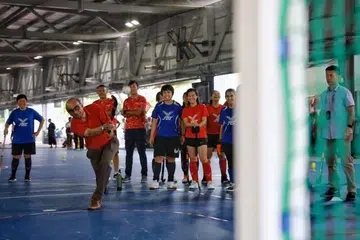 CUBA HOKI: Menteri Kanan merangkap Menteri Penyelaras bagi Dasar Sosial, Encik Tharman Shanmugaratnam, mencuba sukan hoki semasa berada di majlis pembukaan rasmi ActiveSG Sport Village@ Jurong Town pada Ahad. 