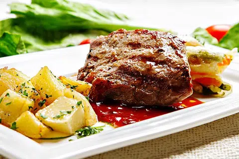Stik daging dinikmati dengan kentang dan sayur-sayuran. 