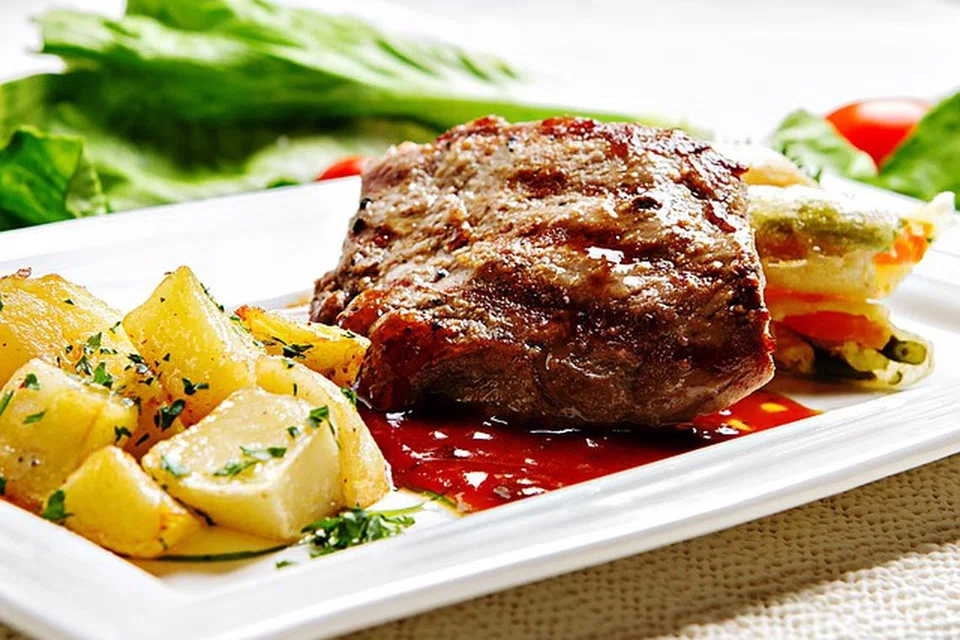 Stik daging dinikmati dengan kentang dan sayur-sayuran. 