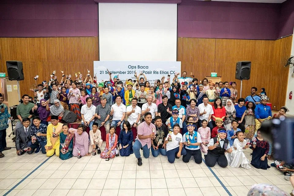 GALAK GUNA BAHASA MELAYU: Encik Zainal Sapari dan Menteri Kanan, Encik Teo Chee Hean, bersama anggota jawatankuasa M3@Pasir Ris dan MAEC Kelab Masyarakat Pasir Ris Elias bergambar beramai-ramai dengan peserta 'Ops Baca' - pertandingan bercerita dalam bahasa Melayu bagi pelajar sekolah rendah yang diadakan sempena Pesta Pembelajaran M3@Pasir Ris pada September lalu. - Foto M³@PASIR RIS-PUNGGOL 