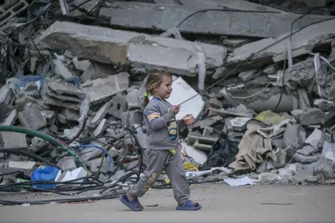 Seorang kanak-kanak Palestin dilihat berjalan sambil memakan aiskrim ketika melarikan diri daripada serangan udara Israel di Bandar Gaza pada 1 April.