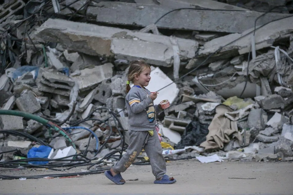 Seorang kanak-kanak Palestin dilihat berjalan sambil memakan aiskrim ketika melarikan diri daripada serangan udara Israel di Bandar Gaza pada 1 April.