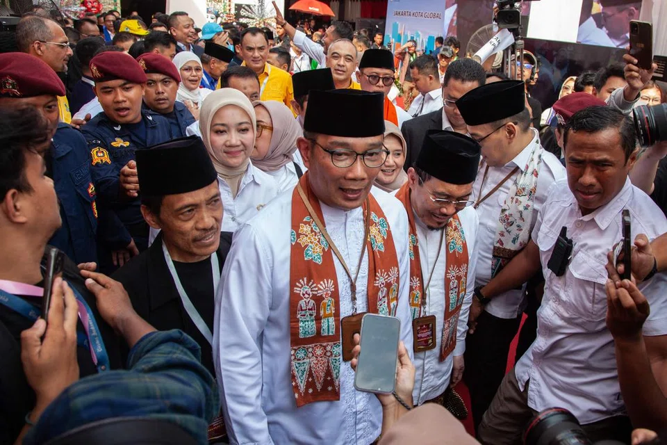 Mantan Gabenor Jawa Barat, Encik Mochammad Ridwan Kamil (tengah), dan pasangan calon beliau, mantan Menteri Pertanian, Encik Suswono (dua dari kanan), di pejabat Suruhanjaya Pilihan Raya Jakarta selepas mendaftar sebagai calon Gabenor dan Timbalan Gabenor Jakarta pada 28 Ogos. 