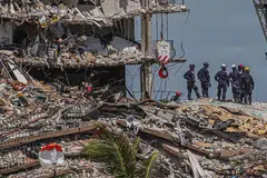 USAHA CARI MANGSA DITERUSKAN: Pasukan mencari dan menyelamat berusaha mencari mangsa yang mungkin terselamat menyusuli kejadian bangunan Champlain Towers South di Surfside, Florida, yang runtuh. - Foto AFP