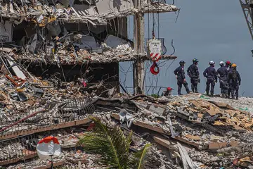 USAHA CARI MANGSA DITERUSKAN: Pasukan mencari dan menyelamat berusaha mencari mangsa yang mungkin terselamat menyusuli kejadian bangunan Champlain Towers South di Surfside, Florida, yang runtuh. - Foto AFP