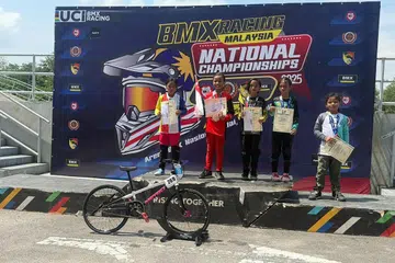 TEMPAT PERTAMA: Pelumba basikal BMX, Irsalina Nursabrina Muhammad Jeehad, atau lebih dikenali sebagai Sally (dua dari kiri), muncul sebagai juara pertandingan BMX di Nilai, Negeri Sembilan, Malaysia, pada 6 Julai.