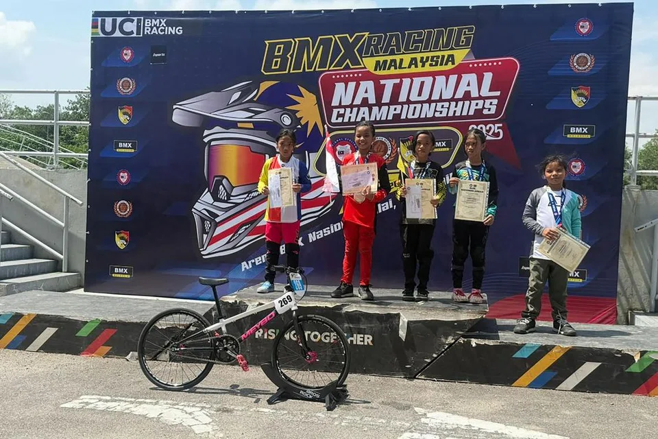 TEMPAT PERTAMA: Pelumba basikal BMX, Irsalina Nursabrina Muhammad Jeehad, atau lebih dikenali sebagai Sally (dua dari kiri), muncul sebagai juara pertandingan BMX di Nilai, Negeri Sembilan, Malaysia, pada 6 Julai.
