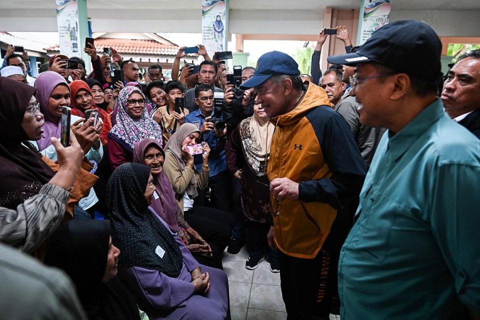 Perdana Menteri Malaysia, Datuk Seri Anwar Ibrahim (dua dari kanan), beramah mesra dengan mangsa banjir semasa melakukan lawatan di Pusat Pemindahan Sementara (PPS) Sekolah Kebangsaan Mangkok di Setiu, Terengganu. Turut sama ialah Menteri Besar Datuk Seri Dr Ahmad Samsuri Mokhtar (kanan).