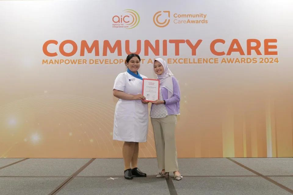 Cik Nur Syaqilah Mohamad (kiri) menerima Anugerah Pembangunan Tenaga Kerja Penjagaan Masyarakat (CCMDA) daripada Menteri Negara (Penerangan dan Pembangunan Digital merangkap Kesihatan), Cik Rahayu Mahzam (kanan), di majlis Anugerah Pembangunan Tenaga Manusia Penjagaan Masyarakat dan Anugerah Kecemerlangan 2024 pada 2 Oktober. 