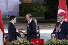 Perdana Menteri, Encik Lawrence Wong (kiri), menerima watikah pelantikan daripada Presiden Tharman Shanmugaratnam semasa majlis angkat sumpah di Istana pada 15 Mei, sambil disaksikan Ketua Hakim  Sundaresh Menon.