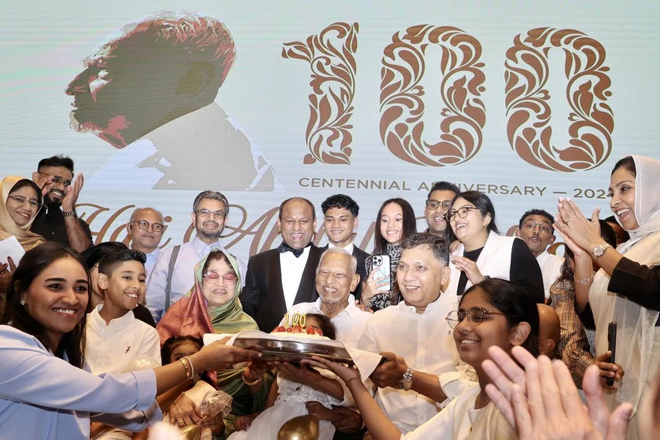 Encik Abdul Gafoore Mohamed Kassim (tengah) menerima kek istimewa sempena meraikan ulang tahun ke-100 beliau dengan disaksikan Ketua Pegawai Eksekutif (CEO) PropNex, Encik Ismail Gafoor (belakang, empat dari kiri) dan lebih 70 tetamu, merangkumi anggota keluarga, saudara-mara dan teman terdekat di Sky Ballroom, Parkroyal di Beach Road pada 16 Jun.
