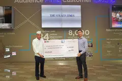 TERUS MENDERMA: Encik Mohamed Abdul Jaleel menyampaikan cek bernilai $500,000 bagi Dana Wang Saku Sekolah The Straits Times (STSPMF) kepada ketua dana yang juga Editor The Straits Times Warren Fernandez. - Foto BH oleh ALPHONSUS CHERN