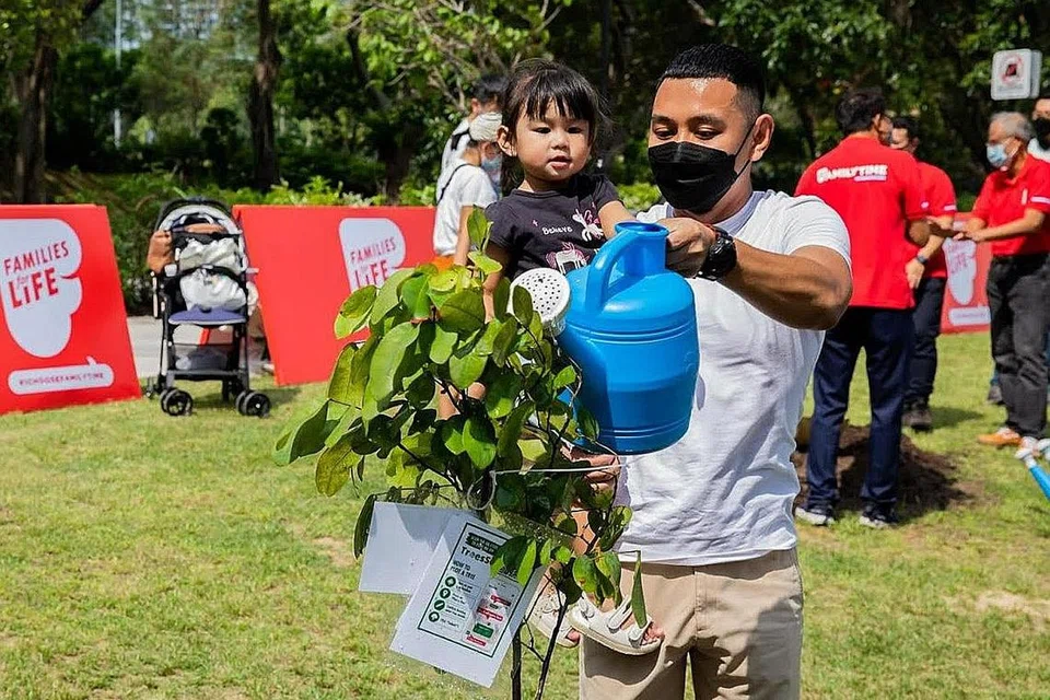 MENGERATKAN HUBUNGAN: Encik Muhammad Fazli Zulkifli, 35 tahun, bersama anak sulungnya, Leia Qaisara, 2 tahun, yang ghairah membantunya menanam pokok mereka di acara FamilyTrees di East Coast Park. - Foto ihsan MUHAMMAD FAZLI ZULKIFLI