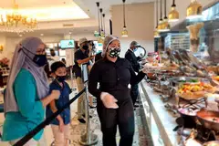 PILIH HIDANGAN: Seorang pelayan dari restoran The Landmark mengambil dan menghidangkan makanan yang dipilih pelanggan dari sajian bufet yang disediakan. Di bawah garis panduan terkini, pelanggan dilarang mengambil makanan mereka sendiri dan akan dibantu oleh seorang pelayan. - FOTO THE LANDMARK VILLAGE HOTEL BUGIS
