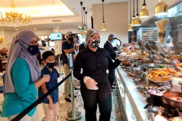 PILIH HIDANGAN: Seorang pelayan dari restoran The Landmark mengambil dan menghidangkan makanan yang dipilih pelanggan dari sajian bufet yang disediakan. Di bawah garis panduan terkini, pelanggan dilarang mengambil makanan mereka sendiri dan akan dibantu oleh seorang pelayan. - FOTO THE LANDMARK VILLAGE HOTEL BUGIS