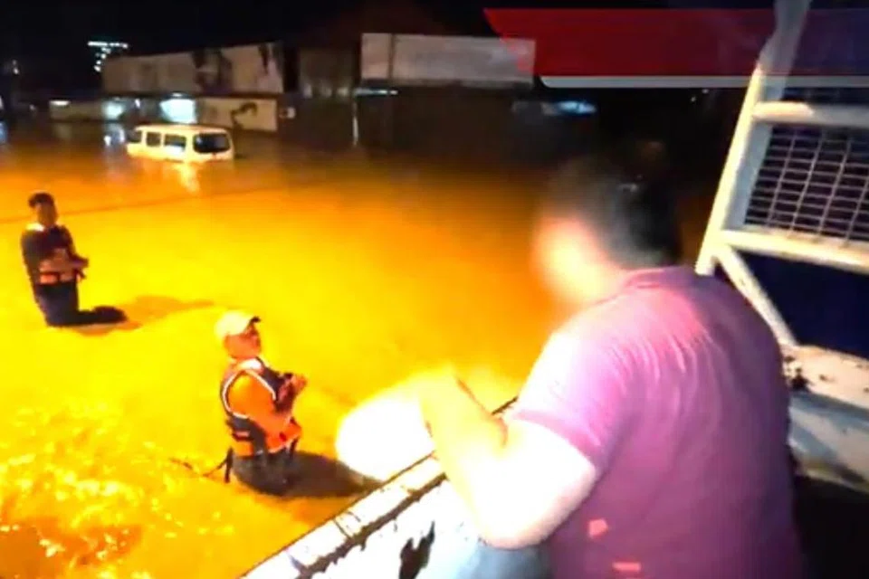 Suami kepada mendiang Monica Ting Siew Kwong, 37 tahun (atas), ketika membantu pasukan mencari dan menyelamat mencari isterinya yang lemas akibat dihanyut arus deras selepas menghantar makanan bagi membantu mangsa terperangkap banjir di Penampang, Kota Kinabalu, Sabah, pada 1.40 pagi, 1 Julai.