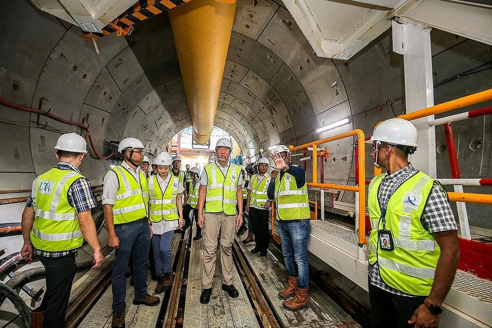 LAWAT TAPAK KERJA: Encik Teo Chee Hean (tengah) bersama Dr Janil Puthucheary dan Cik Sun Xueling (dua dan tiga dari kiri) melawat tapak projek lanjutan terowong Laluan Timur Laut (NELe) semalam. - Foto ZAOBAO