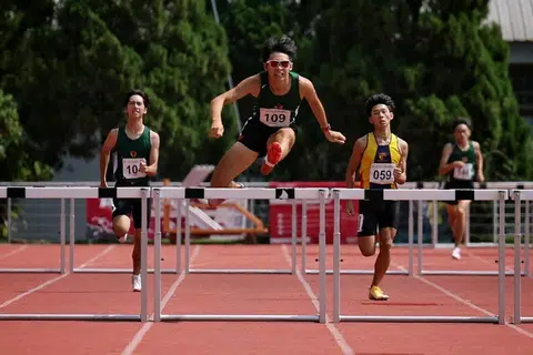 Atlet Institusi Raffles (RI), Daryen Ko (dua dari kiri), melepasi pagar terakhir sebelum memenangi acara final 400 meter lompat pagar lelaki Divisyen A dengan rekod baru 53.75 saat di Stadium Choa Chu Kang pada 13 April.