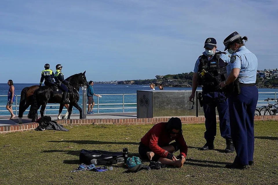 PERIKSA PENDUDUK: Polis di Sydney melakukan rondaan dan pemeriksaan ke atas penduduk di kawasan Bondi Beach sedang bandar itu masih di bawah sekatan pergerakan Covid-19. - Foto REUTERS