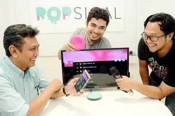 MEROMBAK INDUSTRI KARAOKE: (Dari kiri) Encik Umar, Encik Faruq dan Encik Fadhli telah berusaha menghasilkan Popsical (alat berwarna merah jambu yang dipegang Encik Faruq) sejak setahun lalu. - Foto JOHARI RAHMAT