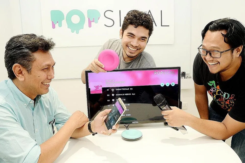 MEROMBAK INDUSTRI KARAOKE: (Dari kiri) Encik Umar, Encik Faruq dan Encik Fadhli telah berusaha menghasilkan Popsical (alat berwarna merah jambu yang dipegang Encik Faruq) sejak setahun lalu. - Foto JOHARI RAHMAT