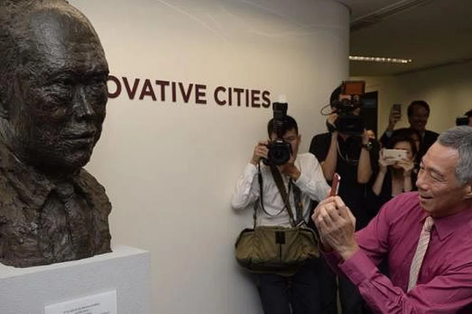 KAMPUS BARU: Perdana Menteri Lee memetik foto patung mendiang Encik Lee Kuan Yew semasa mengunjungi kampus baru Universiti Teknologi dan Reka Bentuk Singapura (SUTD). - Foto THE STRAITS TIMES