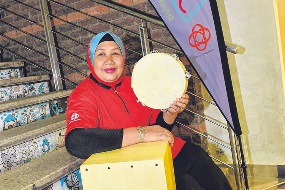 CIK SITI SAMIAH JUNID: Belajar bermain alat muzik genderang tamburin dan dram cajon baru-baru ini di Kelab Masyarakat Yio Chu Kang. - Foto TUKIMAN WARJI