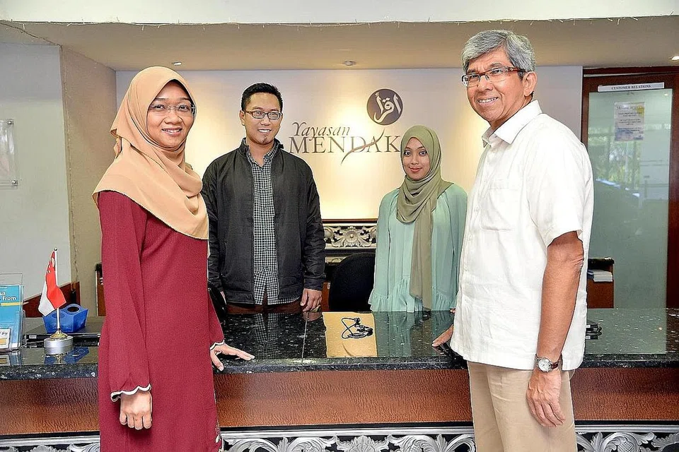 MAINKAN PERANAN UNTUK MASYARAKAT: Dr Yaacob bergambar bersama Ketua Pegawai Eksekutif (CEO) Yayasan Mendaki, Cik Rahayu Buang (kiri) dan dua kakitangan badan bantu diri itu di pejabat Mendaki di Kee Sun Avenue. - Foto M.O. SALLEH