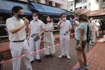 HARAPKAN SOKONGAN PENDUDUK: Bakal calon PAP yang akan bertanding dalam GRC Marsiling-Yew Tee - (dari kanan) Encik Zaqy, Cik Soh, Encik Yam dan Encik Wong - bertemu penduduk di sekitar kawasan Blok 306A Woodlands Street 31 semasa satu lawatan mendekati penduduk pagi semalam. - Foto BH oleh GIN TAY