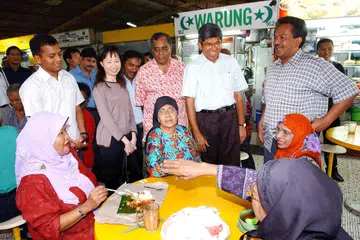 Mantan Menteri Bertanggungjawab bagi Ehwal Masyarakat Islam, Dr Yaacob Ibrahim (berdiri, dua dari kanan) bersama Mantan Setiausaha Parlimen Kanan, Allahyarham Mohamad Maidin Packer Mohd (berdiri, paling kanan) dan Jawatankuasa Pasar Geylang Serai bertemu para pengunjung di pusat makanan pasar itu dalam gambar yang dipetik pada 2005.  