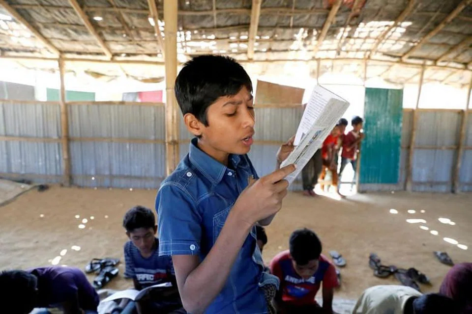 Seorang kanak-kanak membaca buku di sekolah sementara yang dikendalikan guru Rohingya di kem pelarian Kutupalong di Cox's Bazar, Bangladesh pada 7 Februari 2019. FOTO: REUTERS