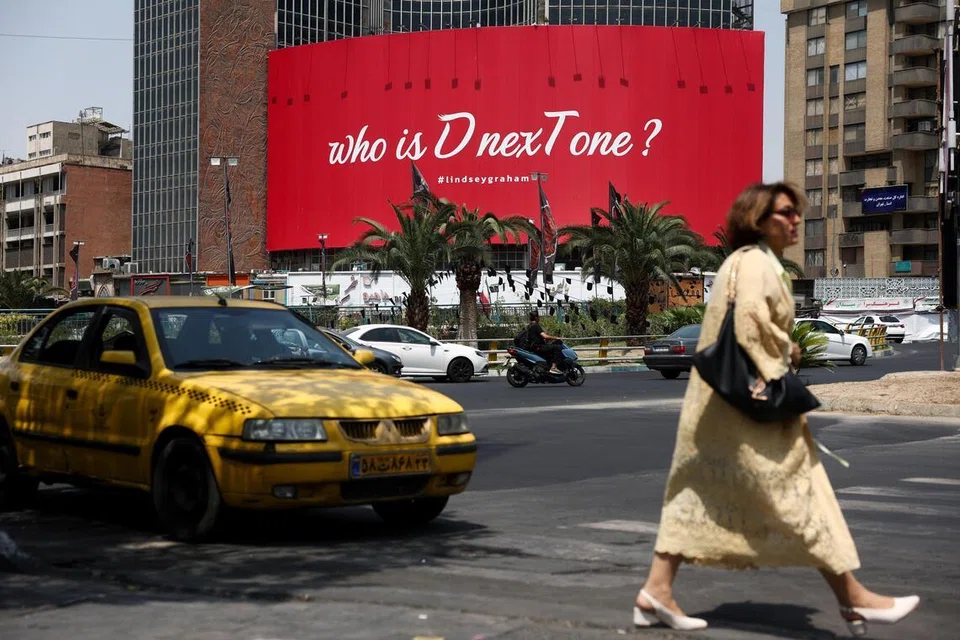 Seorang wanita berjalan berhampiran papan iklan yang memaparkan slogan merujuk kepada Presiden Amerika Syarikat, Donald Trump, di Teheran pada 23 Julai. Ketegangan terus memuncak selepas tentera Amerika Syarikat menyerang Iran bagi malam ke-13 berturut-turut, manakala Trump mengancam melancarkan serangan lebih besar dan Tehran membalas dengan menyasarkan kemudahan tentera Amerika di Bahrain dan Jordan.
