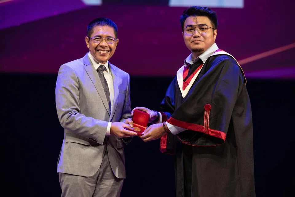 Encik Mohammad Haiqel Mazni bersama dengan Menteri di Pejabat Perdana Menteri merangkap Menteri Kedua (Pendidikan merangkap Ehwal Luar), Dr Mohamad Maliki Osman (di kiri) semasa majlis penerimaan sijil ITE Kolej Central di Ang Mo Kio pada 29 Julai. 