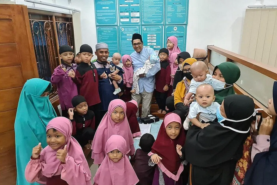 INGIN TERUS MEMBANTU: Ustaz Dr Leyaket Ali (bersongkok hitam) meluangkan masa bersama pengarah dan pengasuh anak-anak syurga yang bakal menghuni rumah anak-anak yatim yang masih dibangunkan di Indonesia ini. - Foto ATTAWASOL INSANIY