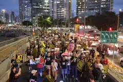 Anggota keluarga tebusan Israel dan penunjuk perasaan mengangkat gambar serta plakad semasa tunjuk perasaan antipemerintah yang menuntut tindakan segera bagi membebaskan tebusan Israel yang ditahan oleh Hamas di Jaluran Gaza sejak 7 Oktober 2023. Gambar dirakam di luar ibu pejabat Kementerian Pertahanan Israel di Tel Aviv pada 6 Ogos 2025. 