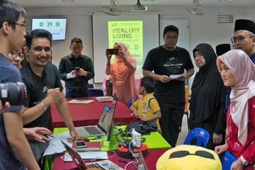 MANFAAT TEKNOLOGI: Cik Rahayu Mahzam (kanan) sedang mendengar rekaan penjelasan belia mengenai rekaan prototaip mereka berhubung tema 'Gaya Hidup Sihat' bagi 'hackathon' Cabaran Teknologi Masjid anjuran Kelab Mendaki. - Foto BH oleh NUR DIYANA TAHA