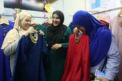 TEMUI PEMINAT SAMBIL BERNIAGA: Azza Elite (tengah) merebut peluang mendekati peminat Singapura yang sentiasa meluangkan masa mendapatkan produk jualannya setiap kali beliau ke sini. - Foto BH oleh PUTRI MARDHIYAH YAZID