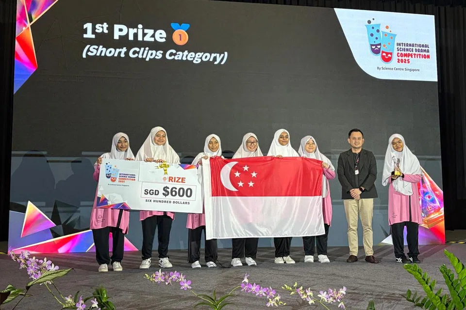 Barisan pelajar Madrasah Al-Ma’arif Al-Islamiah yang muncul juara Pertandingan Drama Sains Antarabangsa (ISDC) kategori Short Clips  pada 3 Ogos - (dari kiri) Humaira Ahmed Nusrath, Khadija Tahira Mohammed Ajeeb, Shariffah Nur A’ishah Syed Kassim Al-Muthar, Nur Kaiyisah Muhammad Azri, Maryam Amjad Mahboob, Nur Syaurah Abu Bakar, dan Misha Anum Abd Rahman - bergambar bersama juri undangan dari Brunei, Encik Allen Jaffran Abdullah Angi.