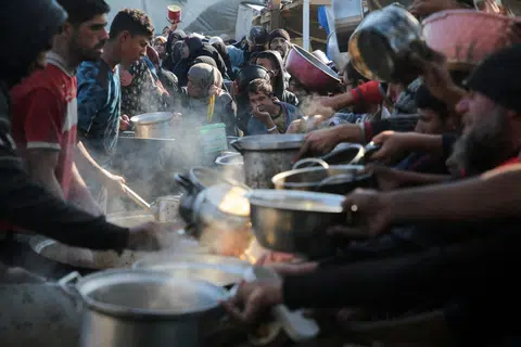 Penduduk Palestin berkumpul untuk menerima makanan yang dimasak di dapur amal di Khan Younis, selatan Gaza, pada 2 Januari sedang perunding Israel meneruskan rundingan di Doha dengan meletakkan pembebasan tebusan sebagai tuntutan utama.