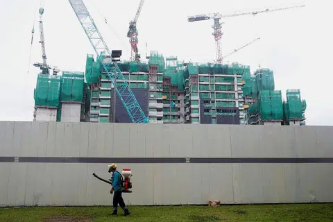 Pekerja melakukan pengabutan dengan racun serangga pada Selasa (30 Ogos) di keliling tapak binaan tempat kes jangkitan Zika ditemui di Singapura. 
