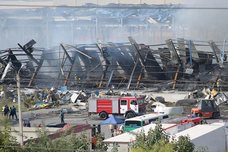 CETUS KEBAKARAN: Pasukan penyelamat membantu mereka yang tercedera di lokasi letupan di sebuah gudang berhampiran lapangan terbang di Tashkent yang menyebabkan seorang meninggal dunia pada Khamis.
