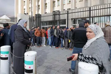Orang ramai beratur di luar ibu pejabat utama Bank Pusat Syria untuk menukar dolar Amerika Syarikat pada kadar harga yang lebih rendah daripada pasaran gelap, di Damsyik pada 30 Disember 2024. 