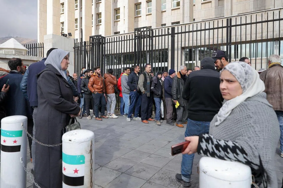 Orang ramai beratur di luar ibu pejabat utama Bank Pusat Syria untuk menukar dolar Amerika Syarikat pada kadar harga yang lebih rendah daripada pasaran gelap, di Damsyik pada 30 Disember 2024. 