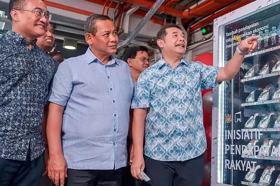 PELUANG NIAGA: Menteri Ekonomi Encik Rafizi Ramli (kanan) bersama Menteri Besar Negeri Sembilan, Datuk Seri Aminuddin Harun (tengah) dan Presiden dan Ketua Pegawai Eksekutif kumpulan, Mohd Azharuddin Mat Sah, melihat sebuah mesin layan diri yang menjual pelbagai jenis makanan tempatan seperti nasi lemak milik peserta IPR pada Majlis Pelancaran Inisiatif Pendapatan Rakyat di Stesen LRT Cempaka, Ampang, Selangor. - Foto BHM