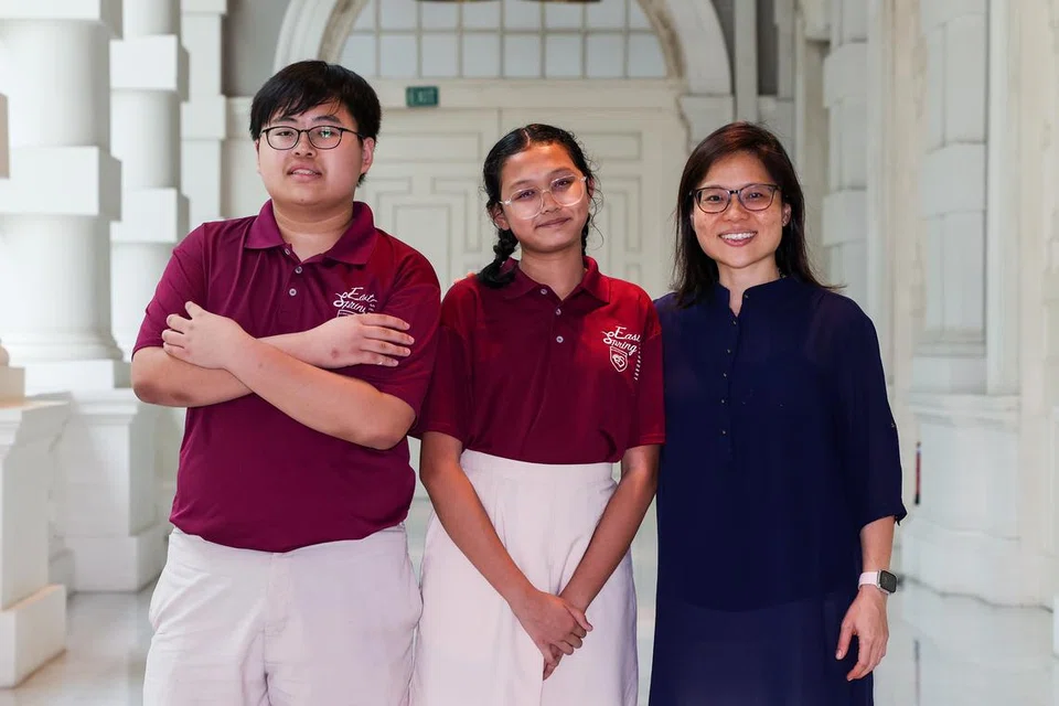 Guru muzik Sekolah Menengah East Spring, Cik Clara Sng (kanan), bersama pelajarnya Myra Nur Nisrina Mohammad Alfian (tengah) dan Seah Jun Hui Xavier.