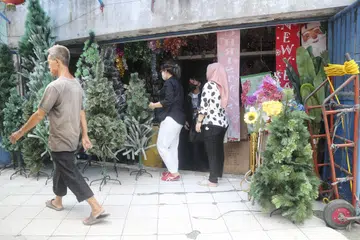 LANGKAH PENCEGAHAN: Sedang penduduk di Jakarta membuat persediaan menyambut Krismas dan Tahun Baru pada 17 Disember, ada di antara mereka yang memakai pelitup untuk mencegah jangkitan Covid-19.