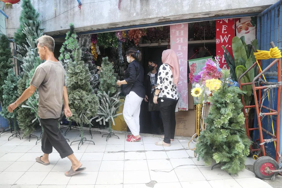 LANGKAH PENCEGAHAN: Sedang penduduk di Jakarta membuat persediaan menyambut Krismas dan Tahun Baru pada 17 Disember, ada di antara mereka yang memakai pelitup untuk mencegah jangkitan Covid-19.