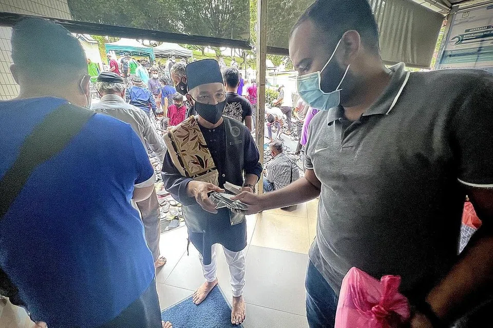 SAMA-SAMA CEGAH DADAH: Encik Ramle Ismail, 54 tahun, yang memimpin dua kumpulan motosikal di sini, mengagihkan kertas butiran, pelekat dan pelitup Dadah Itu Haram, kepada jemaah Masjid Darul Makmur selepas solat Jumaat semalam. - Foto CNB