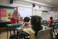 LENGKAPI KEMAHIRAN: Guru AED seperti Cik Mastura M Hashim membantu pelajar menyesuaikan diri apabila melangkah ke darjah satu . - Foto BH oleh KEVIN LIM